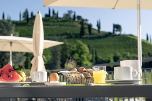 a table with a plate of food and a glass of orange juice at Vineus Tramin in Termeno
