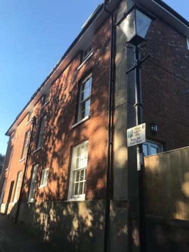 a brick building with a sign in front of it at The Apartment, 24 West End Terrace, Winchester in Winchester