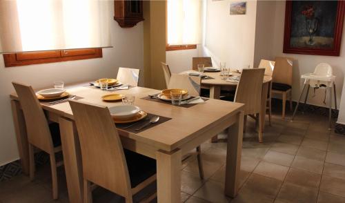 a dining room with tables and chairs with plates and dishes at Pensión Guerrero in Cabra