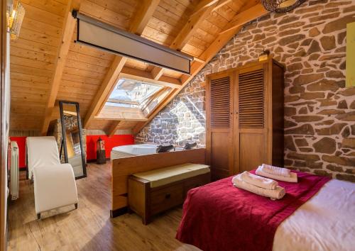 een slaapkamer met een bed en een stenen muur bij Balcon del Pirineo Rural Ordesa in Buesa