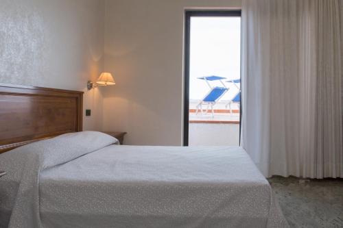 a bedroom with a bed and a large window at Hotel Arcobaleno in Taureana