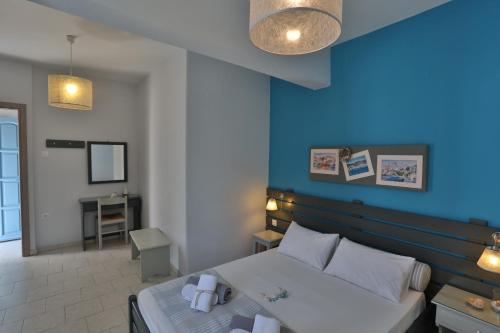 1 dormitorio con cama y pared azul en Kini Bay, en Kini