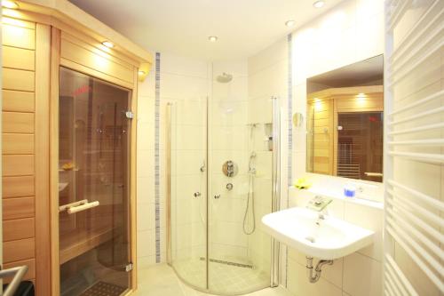 a bathroom with a shower and a sink and a shower at Kurpark-Oase in Warnemünde