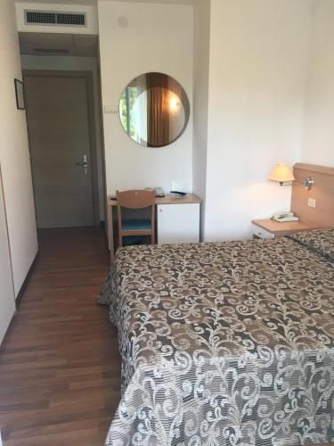 a hotel room with a bed and a mirror at Hotel Bellevue in Lignano Sabbiadoro