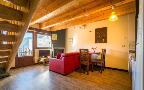 a living room with a red couch and a table at Balcon del Pirineo Rural Ordesa in Buesa