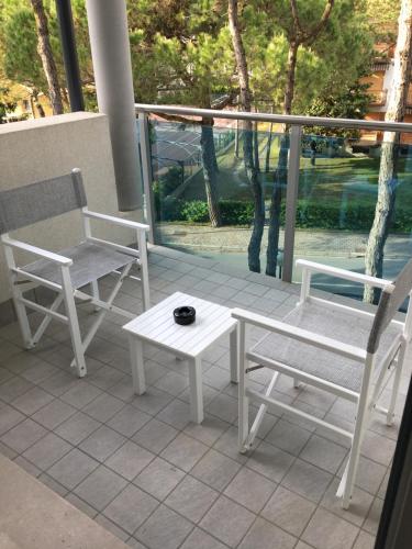 a patio with two chairs and a table and a table and chairs at Hotel Bellevue in Lignano Sabbiadoro
