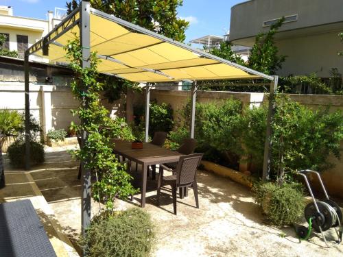 un patio con una mesa y una sombrilla amarilla en Nonno's Nest, en Pezze di Greco