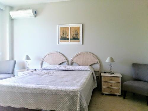 ein Schlafzimmer mit einem Bett und einem Stuhl in der Unterkunft ESTUDIO EN 1a LINEA in Torremolinos