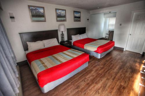 2 camas en una habitación con suelo de madera en Best Budget Inn & Suites Kamloops, en Kamloops