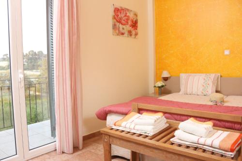 a bedroom with a bed and a balcony at Corfu View in Perama