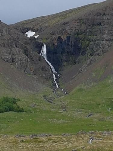 a waterfall on the side of a mountain at Miðjanes Reykhólahrepp in Reykhólar