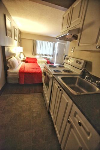 a small kitchen with a bed in a room at Best Budget Inn & Suites Kamloops in Kamloops