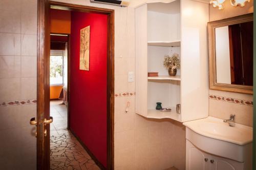 baño con puerta roja y lavamanos en Amelie en San Javier