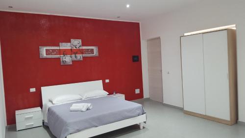 a bedroom with a bed with a red wall at L'isola del sole in Castelluzzo
