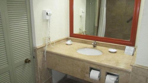 uma casa de banho com um lavatório e um espelho em The Palms Resort of Mazatlan em Mazatlán