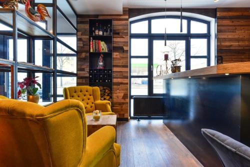 a living room with two yellow chairs and a table at Hotel Haunstetter Hof Augsburg in Augsburg