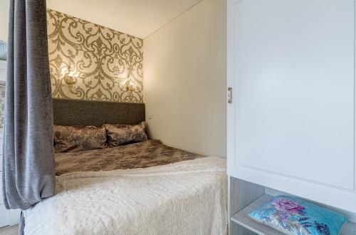 a small bedroom with a bed and a wall at Bright apartment near Akropolis in Vilnius