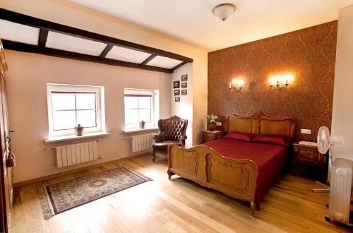 a bedroom with a red bed and two windows at Aparthotel Stora Antis in Klaipėda