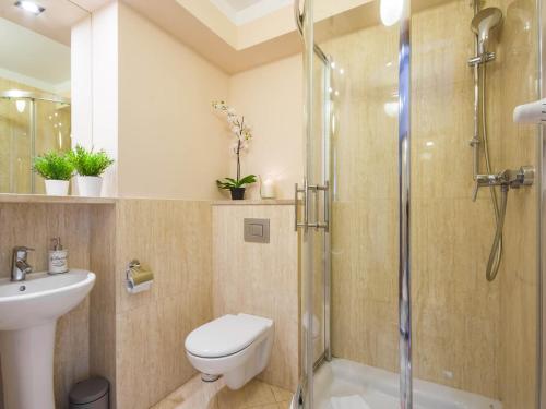 a bathroom with a shower and a toilet and a sink at VacationClub - Villa Mistral Apartament 3 in Świnoujście