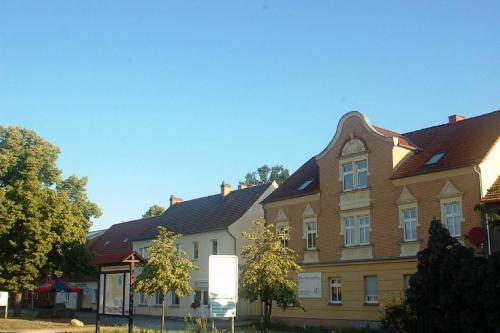 a large brick building with a brown roof at Appartements am Dorfkrug _ Ferienw in Freienhufen