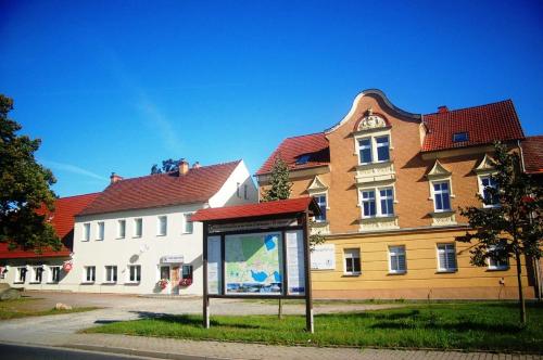 a large building with a sign in front of it at Appartements am Dorfkrug _ Ferienw in Freienhufen