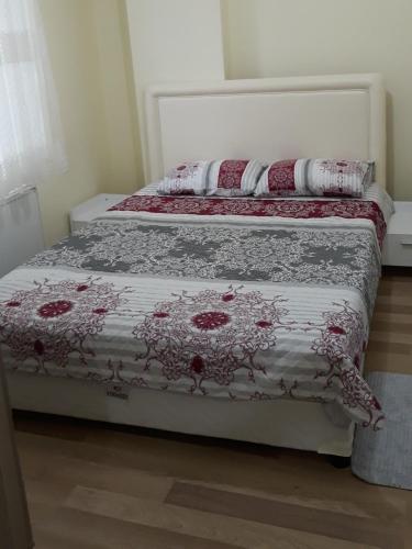a bed with a red and white comforter on it at Cerit Pansiyon in Gokceada Town