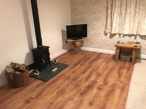a living room with a wood stove and a television at Thrush Nest Cottages - Wren Cottage sleeps 4, 2 bedrooms & Stable Cottage sleeps 2, 1 bedroom in York