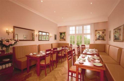 una sala da pranzo con un lungo tavolo e sedie di Hotel Preuss im Dammtorpalais ad Amburgo