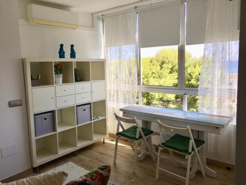 ベナルマデナにあるSan Francisco Apartamentoのテーブルと椅子2脚、窓が備わる客室です。