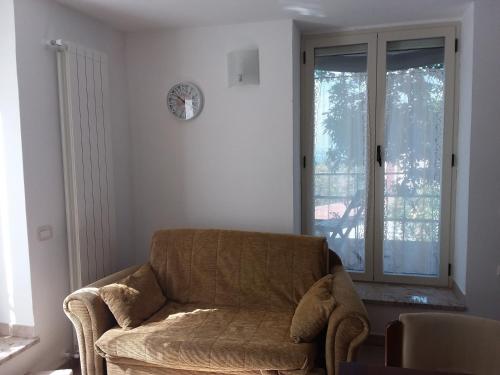 a living room with a chair and a clock on the wall at Lodge Rosa in Agropoli