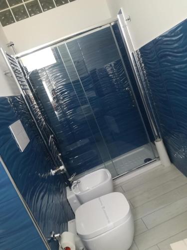 a bathroom with a toilet and a blue wall at Guest House Domus Cicerone in Formia