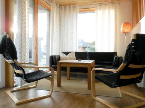 ツィローにあるSchwedenrotes Ferienhaus Wismarのリビングルーム(ソファ、テーブル、椅子付)