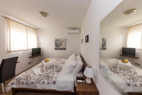 a bedroom with two beds and two windows at Villa Hedonist in Seget Vranjica