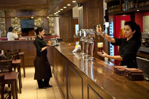 two women standing at a bar in a restaurant at Hotel De Los Andes in Ushuaia