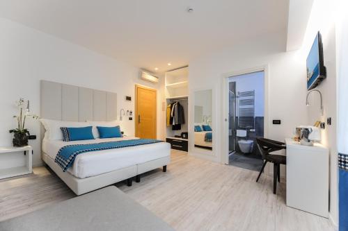a bedroom with a bed and a desk and a bathroom at Bellini Relais in Lignano Sabbiadoro