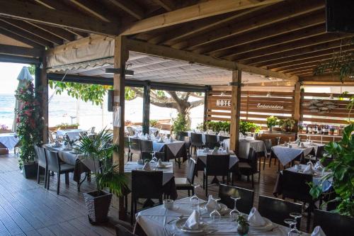 un comedor con mesas y sillas y el océano en Hotel Embarcadero de Calahonda de Granada en Calahonda