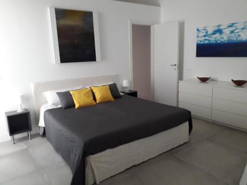 ein Schlafzimmer mit einem großen Bett mit gelben Kissen in der Unterkunft Casa Madonia in Terrasini