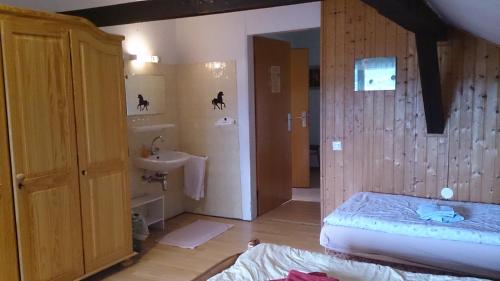 a bedroom with a bed and a bathroom with a sink at Gästehaus Burgwald-Trekking in Mittelsimtshausen