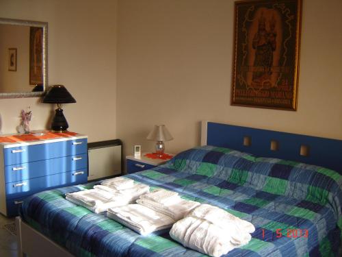 een slaapkamer met een bed met handdoeken erop bij casa giafra in S'archittu Cuglieri