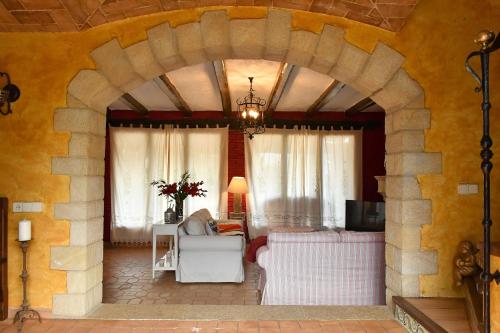 a living room with a stone archway with a couch at Mas Valoria in Peratallada