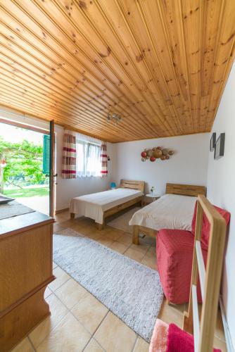 a bedroom with two beds and a wooden ceiling at Das Weinberghaus in Ratsch an der Weinstraße