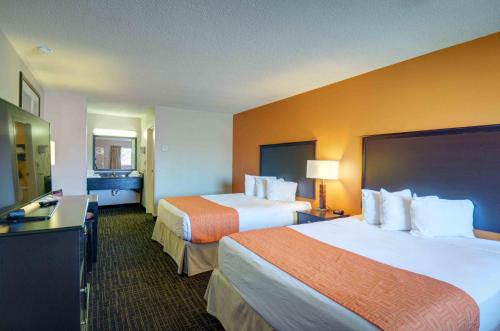 a hotel room with two beds and a desk at North Platte Inn and Suites in North Platte