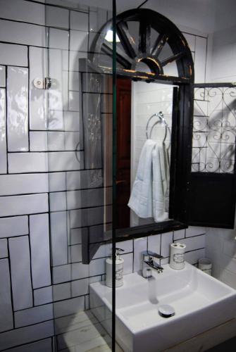 a white bathroom with a sink and a mirror at Fotinos House Skiathos in Skiathos