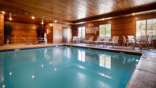 オークデールにあるBest Western Plus Rama Inn & Suitesのテーブルと椅子付きの客室内のスイミングプールを利用できます。