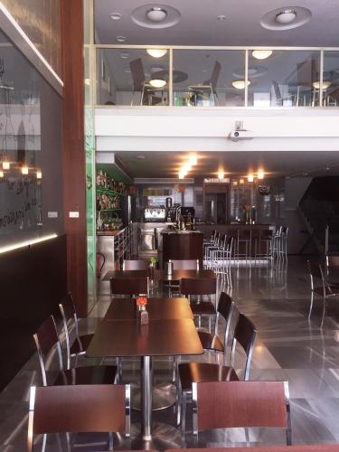 a restaurant with tables and chairs and a bar at Hostal Nirvana in Ponferrada