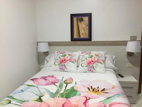 um quarto com uma cama com flores cor-de-rosa em Casa Estrella em Tebra