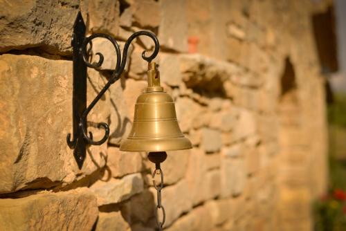 a bell hanging on a stone wall at Mas Valoria in Peratallada