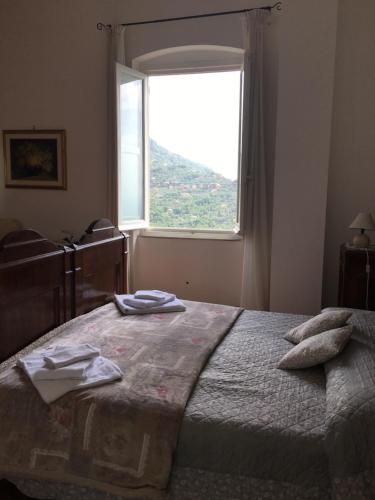 Schlafzimmer mit einem Bett und einem großen Fenster in der Unterkunft B&B Villa Orchidea in Camogli