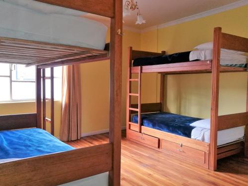 two bunk beds in a room with wooden floors at Community Hostel Quito in Quito
