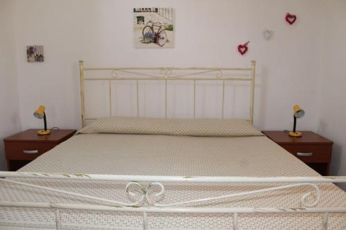 マティーノにあるCasa Vacanze Rosaのベッドルーム1室(白いベッド1台、ナイトスタンド2台付)